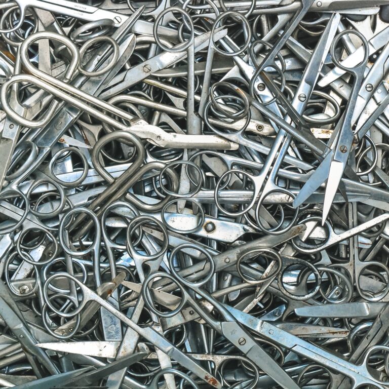 Close-up of used surgical scissors filling the entire frame, stacked.